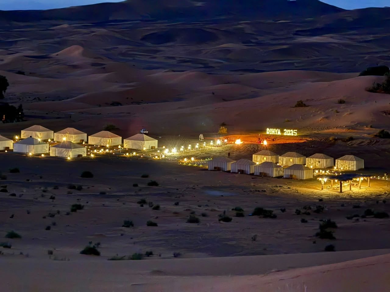 Merzouga luxury camp lit up at night in the Erg Chebbi dunes